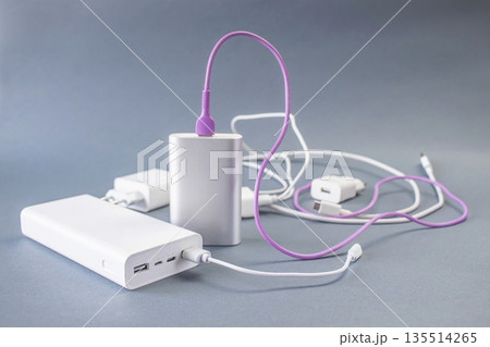 Portable portable chargers, power banks and charging accessories on gray background 135514265