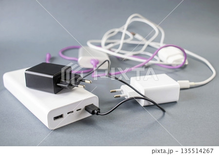 Portable portable chargers, power banks and charging accessories on gray background 135514267