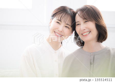 笑顔で寄り添う母と娘　幸せいっぱいの大笑いのクローズアップ 135514511