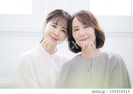 笑顔で寄り添う母と娘 幸せいっぱいの大笑いのクローズアップ 笑顔で寄り添う母と娘 幸せいっぱいの大笑いのクローズアップ 135514513