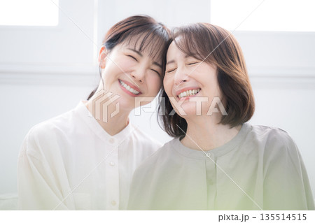 笑顔で寄り添う母と娘 幸せいっぱいの大笑いのクローズアップ 笑顔で寄り添う母と娘 幸せいっぱいの大笑いのクローズアップ 135514515