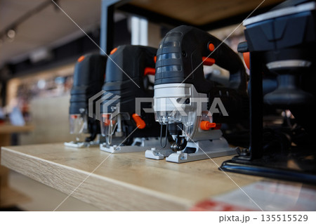 A collection of jigsaw puzzles is neatly arranged on a wooden shelf 135515529