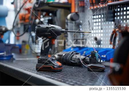 Cordless drill on a table in a workshop Cordless drill on a table in a workshop 135515530