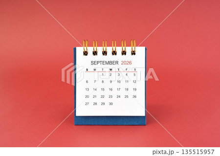 September 2026 white desk calendar on red background. 135515957