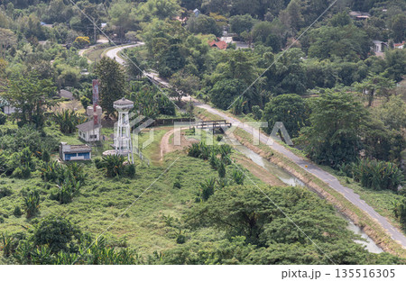Canal and drainage system from Drainage Khun Dan Prakan Chon Dam with scenery cuts through lush green hills amidst landscape nature. 135516305