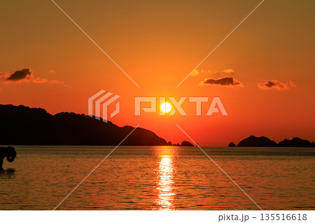 夕日に染まる愛媛県八幡浜の海と島影が広がる穏やかな夕景風景 135516618