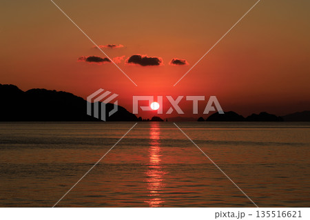 夕日に染まる愛媛県八幡浜の海と島影が広がる穏やかな夕景風景 135516621