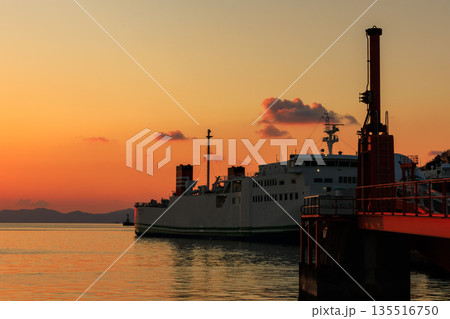 夕焼けに染まる愛媛・八幡浜港と停泊するフェリーの幻想的な風景 135516750