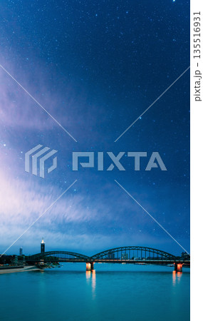 Night View Of Hohenzollern Arch Bridge Over The River Rhine, Germany. Europe. Cologne. Night starry sky with stars in blue heaven 135516931