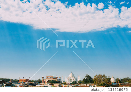 Taj Mahal at midday under clear blue sky with white cumulus clouds Taj Mahal at midday under clear blue sky with white cumulus clouds 135516976