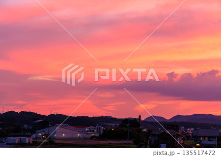 田園と町並みに広がるピンクと紫が美しい幻想的な夕焼け空 田園と町並みに広がるピンクと紫が美しい幻想的な夕焼け空 135517472