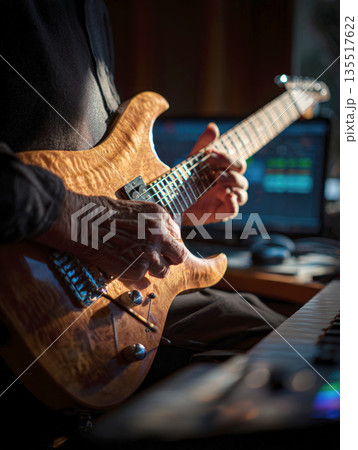 Close-up of an elderly man's hands, showcasing the texture of age, passionately playing a beautifully figured electric guitar. The warm light highlights the wood grain and metal hardware 135517622