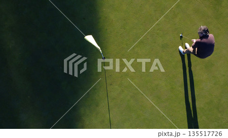 Male golfer in action during game on golf course under sunlight. 135517726