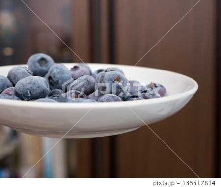 Frozen bog bilberry on a plate. 135517814