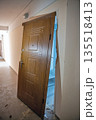 Damaged apartment entrance door in hallway during renovation. 135518413