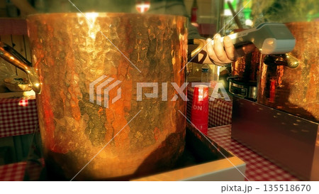 Vendors selling traditional mulled wine and hot cider in copper pots at the Annecy Christmas market, France 135518670