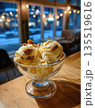 A delightful and appetizing photograph of a creamy frozen dessert, captured indoors with warm lighting contrasting the cold winter street scene outside the window, conveying a cozy treat 135519616