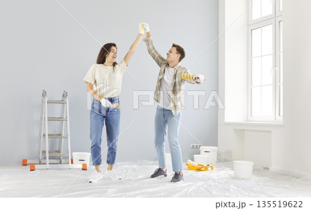 Happy young married couple enjoying home renovation fun, repair after moving into new house Happy young married couple enjoying home renovation fun, repair after moving into new house 135519622