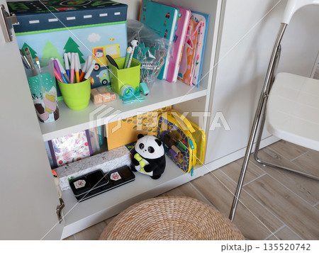 New modern children toys in white cupboard on shelf. Cleaning and storage in home. Design and order. New modern children toys in white cupboard on shelf. Cleaning and storage in home. Design and order. 135520742