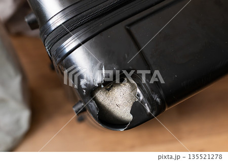 Damaged black suitcase with broken corner after rough baggage handling at airport Damaged black suitcase with broken corner after rough baggage handling at airport 135521278
