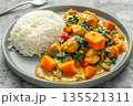 Flat lay of domoda vegetables stew with pumpkin, chicken simmered in creamy peanut sauce and rice on grey plate on table, traditional african cuisine, delicious traditional dish of Gambia 135521311