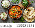 Top view of chicken tikka masala with spicy curry meat, basmati rice in bowl and naan bread on dark grey background, traditional Indian dish 135521321