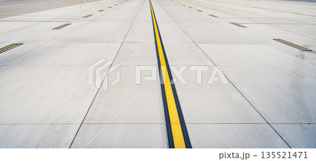 Airport runway. Surface level of long airport runway with yellow marking. Airport runway ready for airplane landing or taking off. Directional sign marking on tarmac of runway at commercial airport 135521471