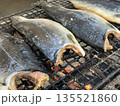 2枚おろしの半身で丸ごと網の上で炭火調理する美味しそうな焼鮭 135521860