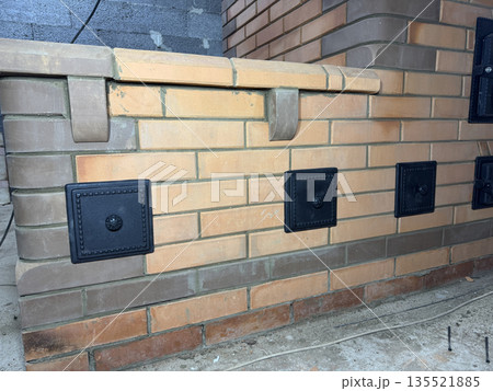 Construction of a heating stove with a sleeping bench. Close-up of the bench. Construction of a heating stove with a sleeping bench. Close-up of the bench. 135521885