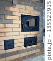 Construction of a heating stove. Doors of the firebox, ash pit, and cleaning channels are visible. Construction of a heating stove. Doors of the firebox, ash pit, and cleaning channels are visible. 135521915