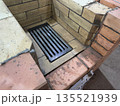Fresh brickwork of a heating stove. The firebox is made of fireclay brick, a cast iron grate is installed. Close-up. Fresh brickwork of a heating stove. The firebox is made of fireclay brick, a cast iron grate is installed. Close-up. 135521939
