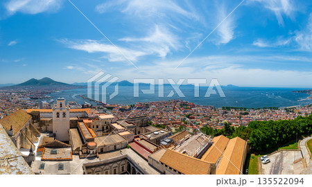Panoramic top view of Naples rooftops from Castel Sant Elmo, with the sea in the distance and Mount Vesuvius rising above the city on a clear summer day. Panoramic top view of Naples rooftops from Castel Sant Elmo, with the sea in the distance and Mount Vesuvius rising above the city on a clear summer day. 135522094