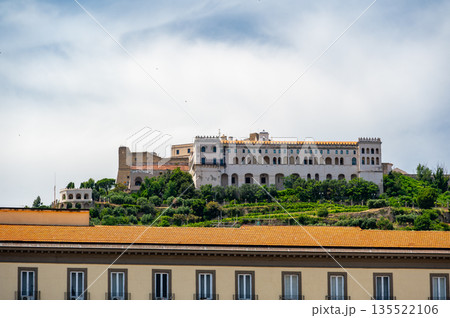 View of Castel Sant Elmo from below in Naples, Italy, showing the fortress towering above the city with its massive stone walls and historic hilltop presence. View of Castel Sant Elmo from below in Naples, Italy, showing the fortress towering above the city with its massive stone walls and historic hilltop presence. 135522106