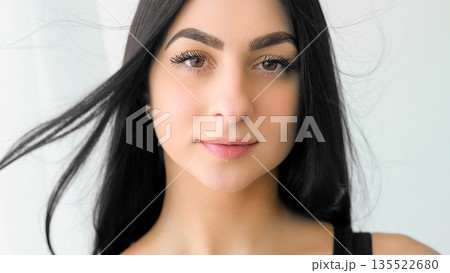 Face beauty. Healthy hair. Tender young woman with long dark locks blowing on wind. Female facial glamour cosmetics isolated on white. Face beauty. Healthy hair. Tender young woman with long dark locks blowing on wind. Female facial glamour cosmetics isolated on white. 135522680