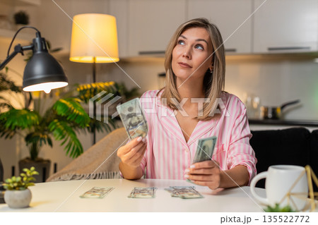 Adult woman counts cash dollars sorts budget piles expenses savings plans family finance night plan 135522772