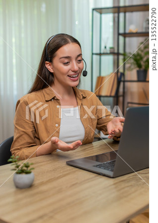 Young woman hosting online conference on laptop speaking in microphone with clear professional style 135522790