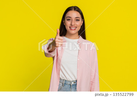 Woman smiling showing thumbs up gesture with confidence approval positivity happy emotional reaction Woman smiling showing thumbs up gesture with confidence approval positivity happy emotional reaction 135522799