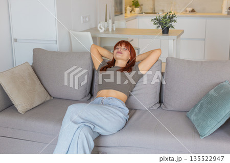 Young woman sits down and relaxes after work slow breath calm mood gentle pause and rest with peace 135522947