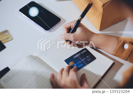 Online payment, Hands of woman holding a credit card and using smart phone for online shopping Online payment, Hands of woman holding a credit card and using smart phone for online shopping 135523204