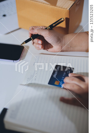 Online payment, Hands of woman holding a credit card and using smart phone for online shopping 135523205