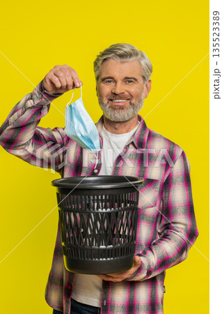 Mature man taking off medical mask flu treatment cure ending of pandemic quarantine disease recover Mature man taking off medical mask flu treatment cure ending of pandemic quarantine disease recover 135523389
