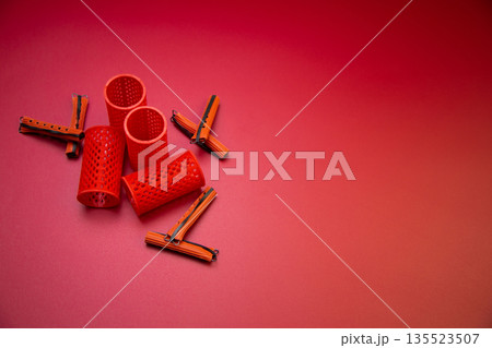 Round and small curlers of different shapes for creating voluminous hairstyles and curls on a pink background with space for text. The concept of hairstyles, volume, curls and self-care. High quality Round and small curlers of different shapes for creating voluminous hairstyles and curls on a pink background with space for text. The concept of hairstyles, volume, curls and self-care. High quality 135523507