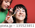 woman paints face with makeup 135523851