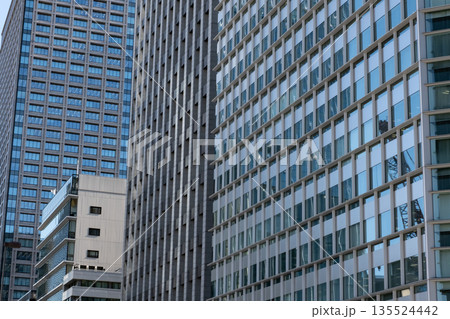 高層ビルを見上げるオフィス街の風景 135524442