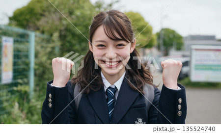 女性が制服姿で屋外で元気に笑顔でガッツポーズ 135524740