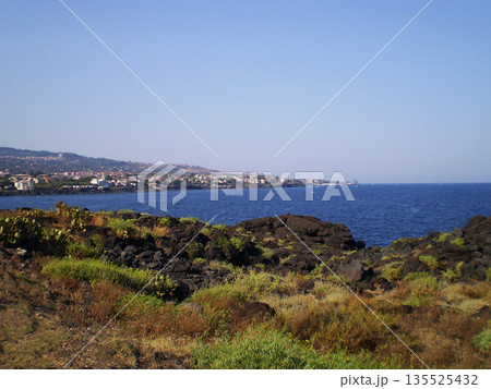 Catania embankment overlooking the beautiful blue sea in Sicily, Italy, featuring a scenic coastal promenade with views of the Ionian Sea. Picturesque Mediterranean landscape highlighting the seaside Catania embankment overlooking the beautiful blue sea in Sicily, Italy, featuring a scenic coastal promenade with views of the Ionian Sea. Picturesque Mediterranean landscape highlighting the seaside 135525432