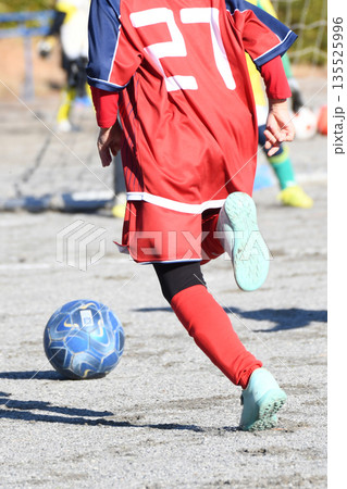 ドリブルするサッカー選手 135525996