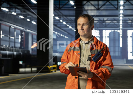 Factory employee monitoring automation equipment in safety gear, representing industrial development and production line consistency. Strong workforce for manufacturing efficiency. Factory employee monitoring automation equipment in safety gear, representing industrial development and production line consistency. Strong workforce for manufacturing efficiency. 135526341