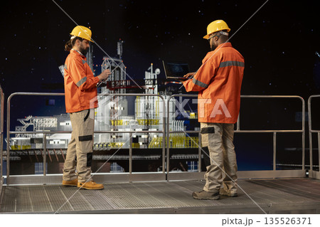 Drilling ship engineering team use AI deep learning to inspect infrastructure integrity using laptop. Offshore platform colleagues performing machinery checkup with artificial intelligence technology Drilling ship engineering team use AI deep learning to inspect infrastructure integrity using laptop. Offshore platform colleagues performing machinery checkup with artificial intelligence technology 135526371