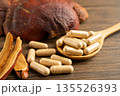 Dried lingzhi mushroom with capsule drug, alternative medicine herbal organic herb. 135526393